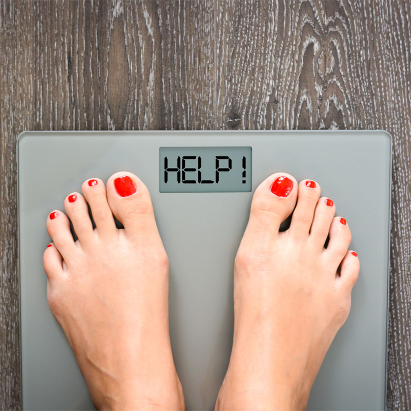 two feet on a bathroom scale to illustrate peptide use to help with weight loss