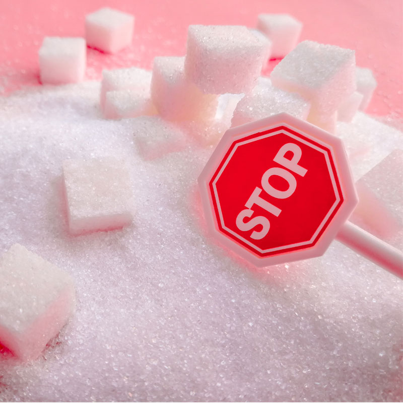stop sign on background of sugar cubes to illustrate high blood sugar