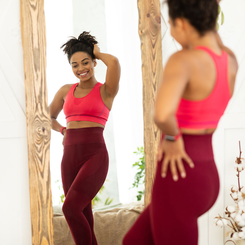 woman posing near mirror to illustrate peptide therapy for weight loss